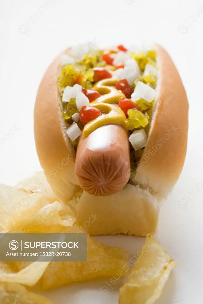 Hot dog with relish, mustard, ketchup, onions and crisps