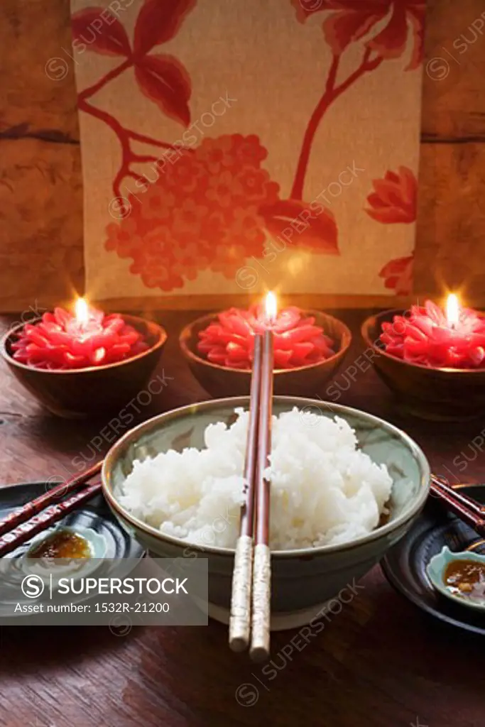 Bowl of rice in front of burning candles (Thailand)