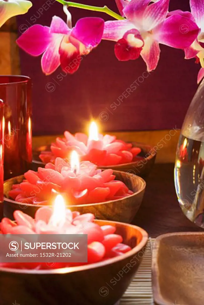 Thai table decoration: red flower candles and orchids