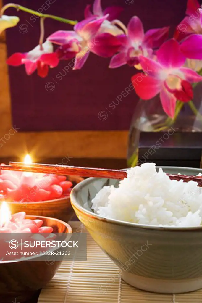 Bowl of rice beside burning candles (Thailand)