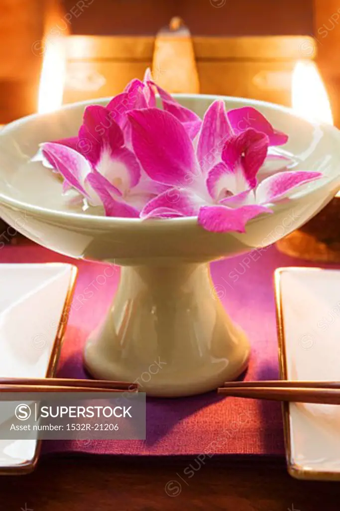 Thai table decoration: orchids in bowl of water