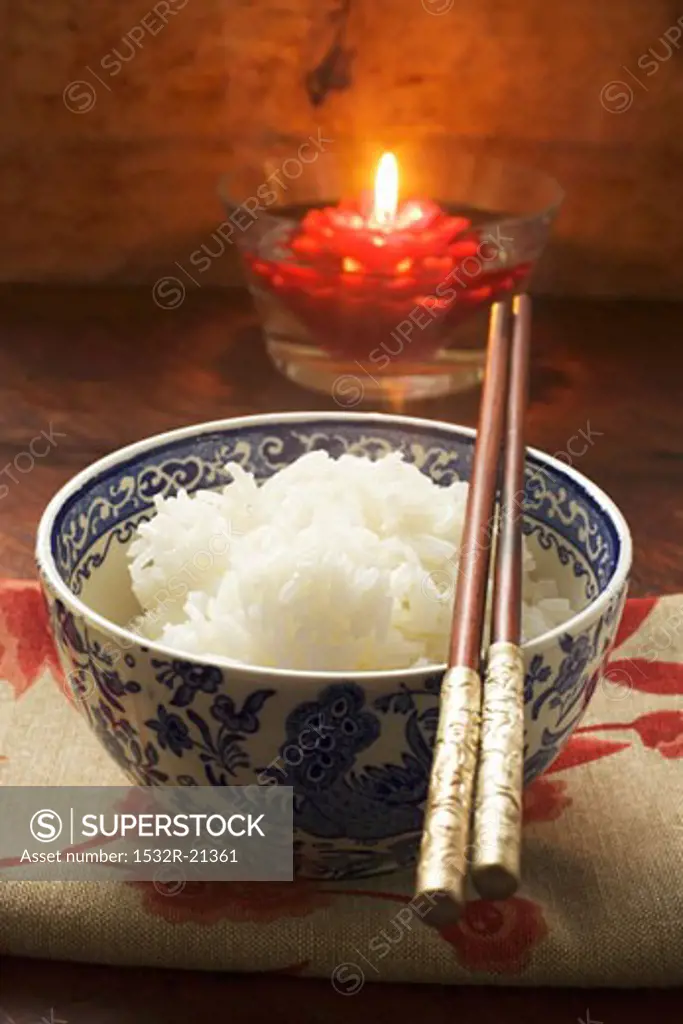Bowl of rice in front of floating candle (Asia)