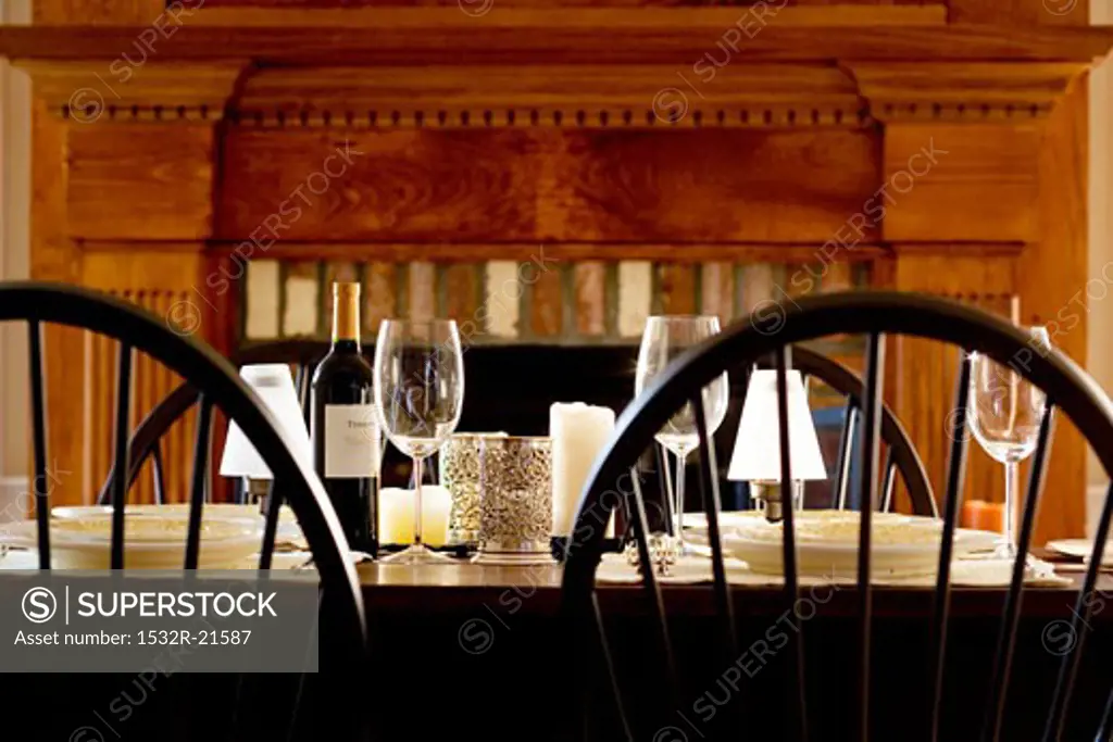 Laid table with red wine in front of fireplace