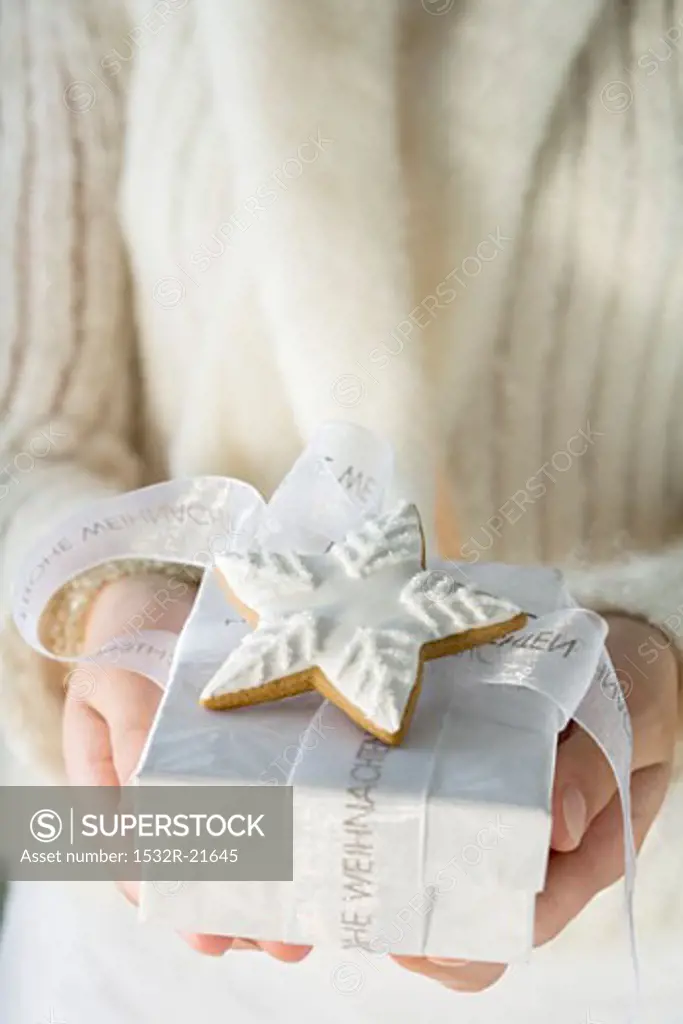Woman holding Christmas gift with cinnamon star