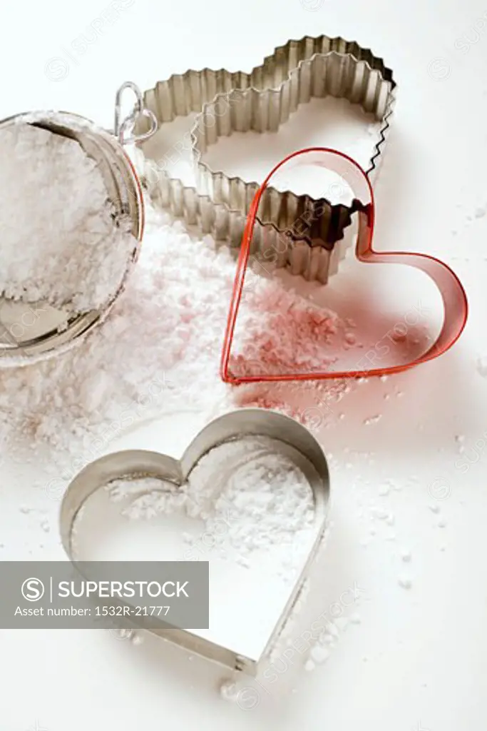 Heart-shaped biscuit cutters with flour