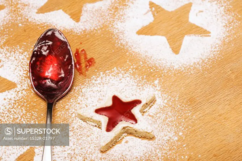 Star-shaped jam biscuit and spoon with jam