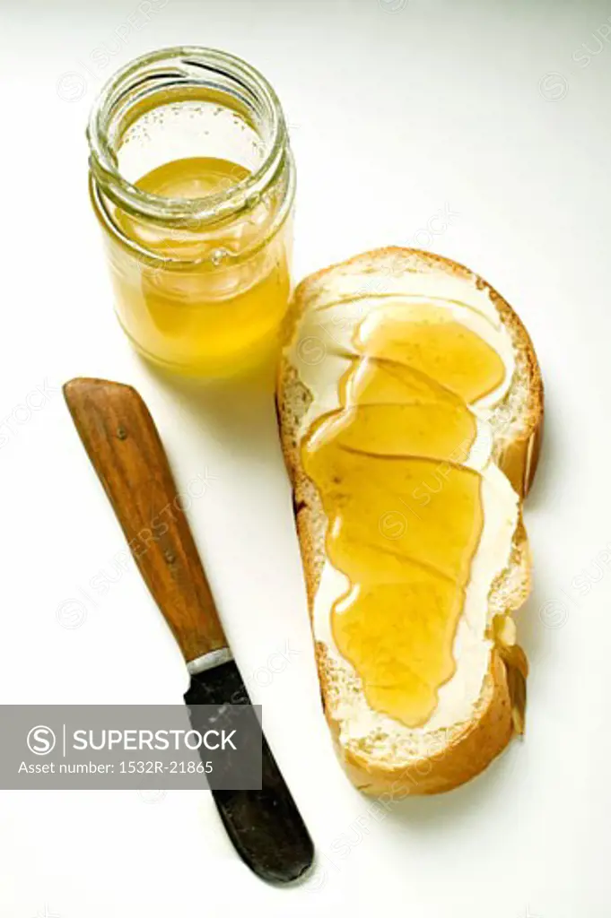 Slice of bread plait with butter & honey, knife & honey jar