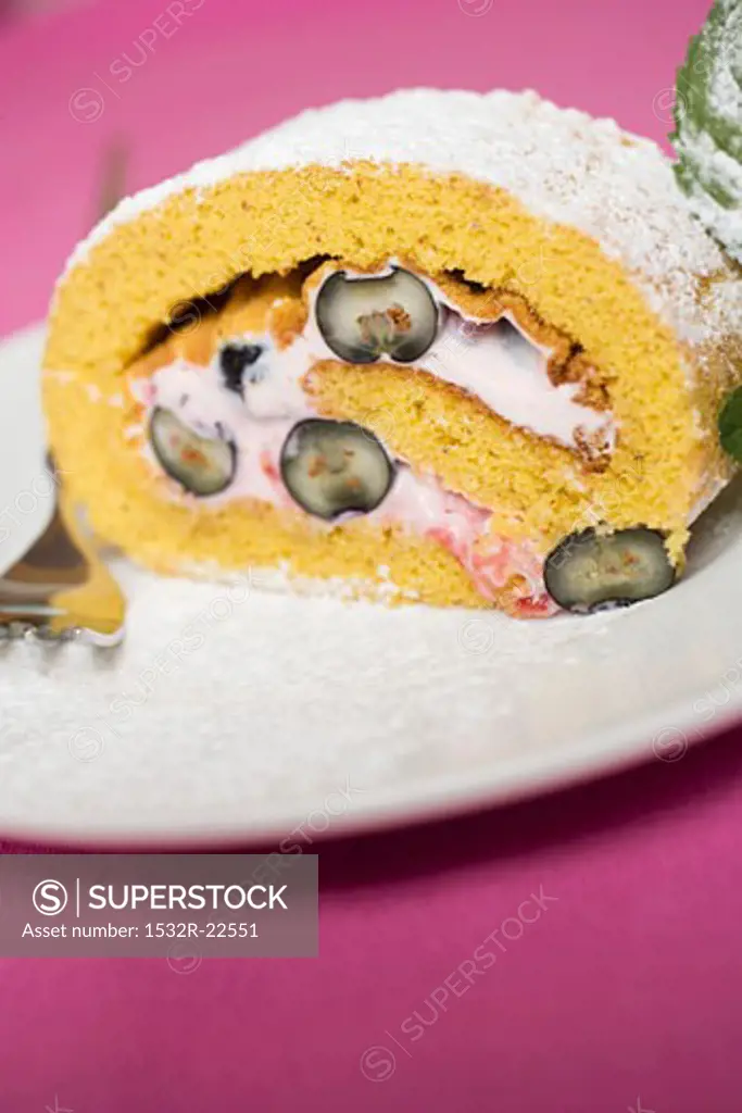 A slice of sponge roulade with berry & quark filling