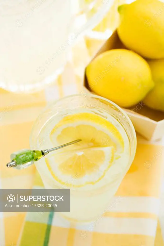 Lemonade in a glass with a lemon slice on a cocktail stick