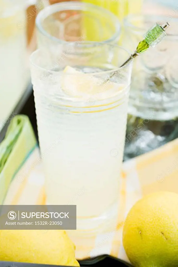 A glass of lemonade and lemons