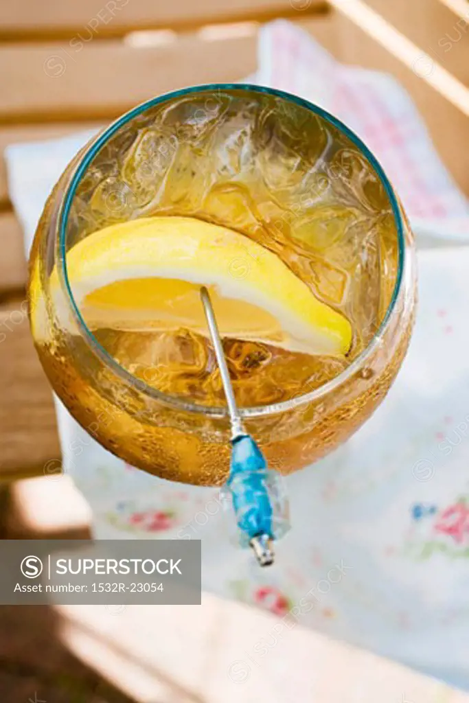 Rum and tonic with ice cubes and lemon wedge