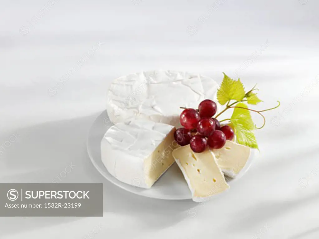 Two rounds of Camembert and grapes on a plate