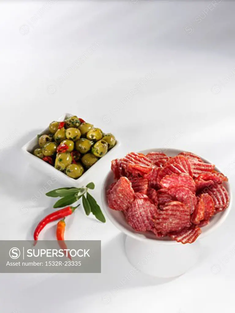 Slices of salami, green olives and chillies
