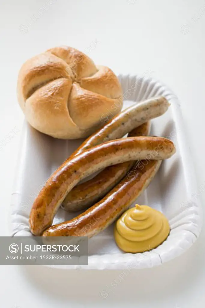 Four sausages with mustard and bread roll