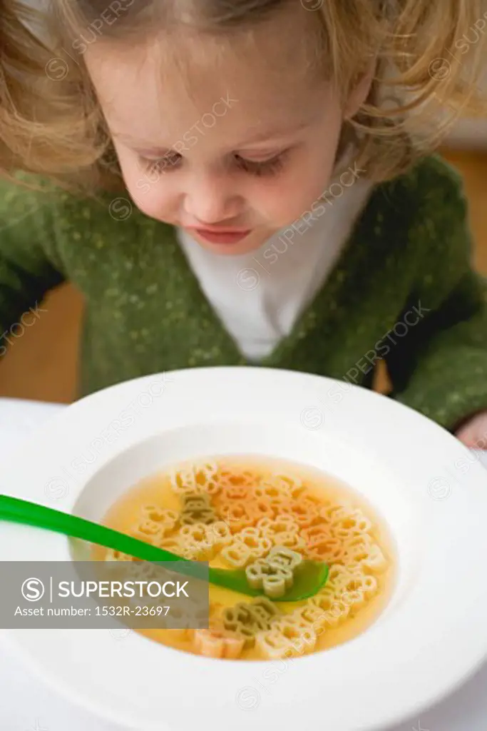 Small girl with teddy bear noodle soup
