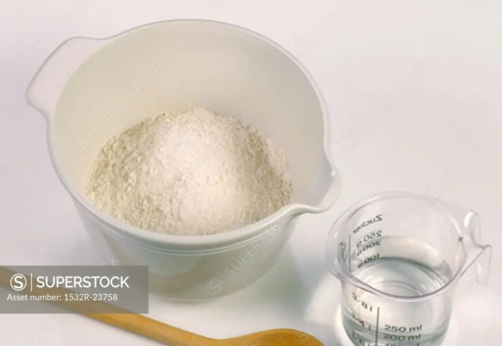 Flour in a bowl and water in a measuring jug
