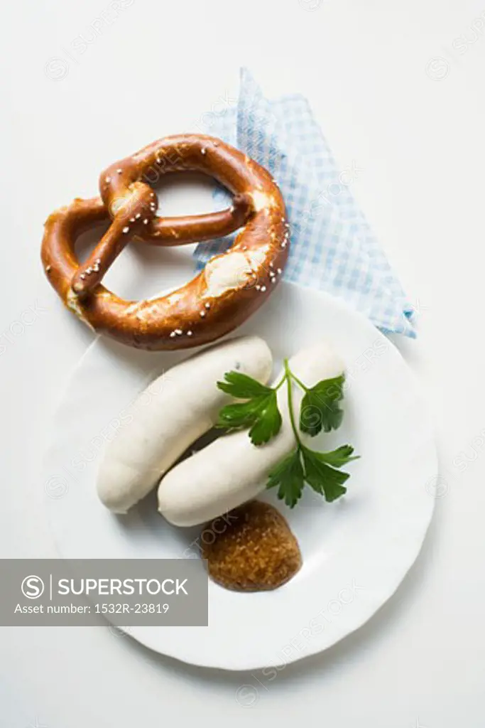 Two Weisswurst (white sausages) with pretzel and mustard
