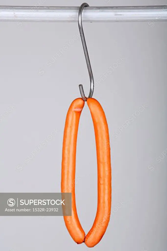A pair of frankfurters on a hook