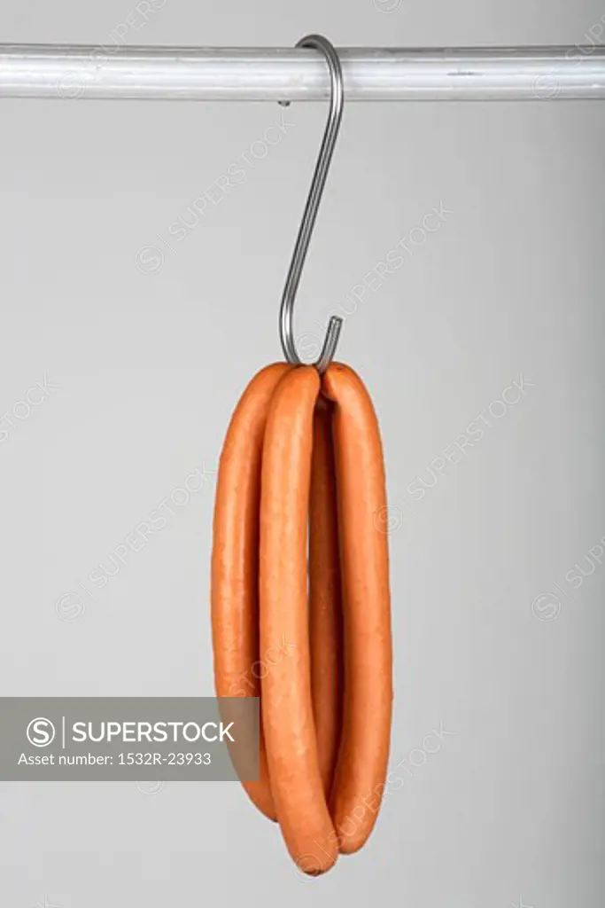 Two pairs of frankfurters on a hook