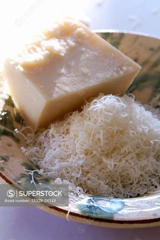 Parmesan, a piece and grated in a deep plate