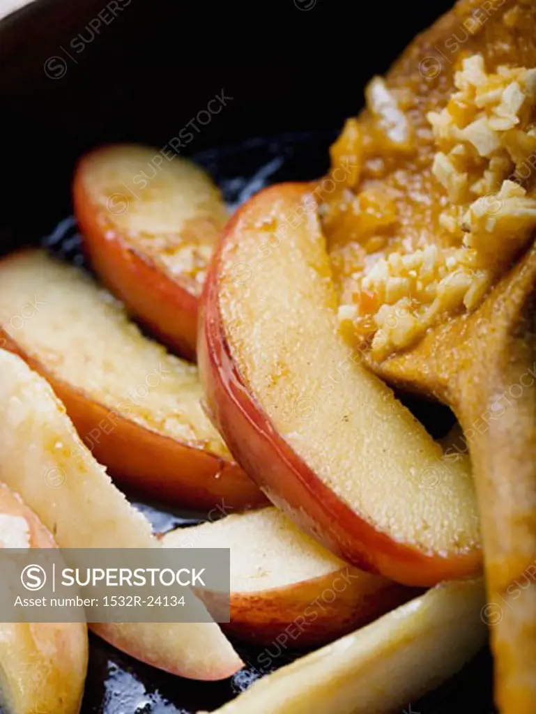 Fried apple wedges in frying pan