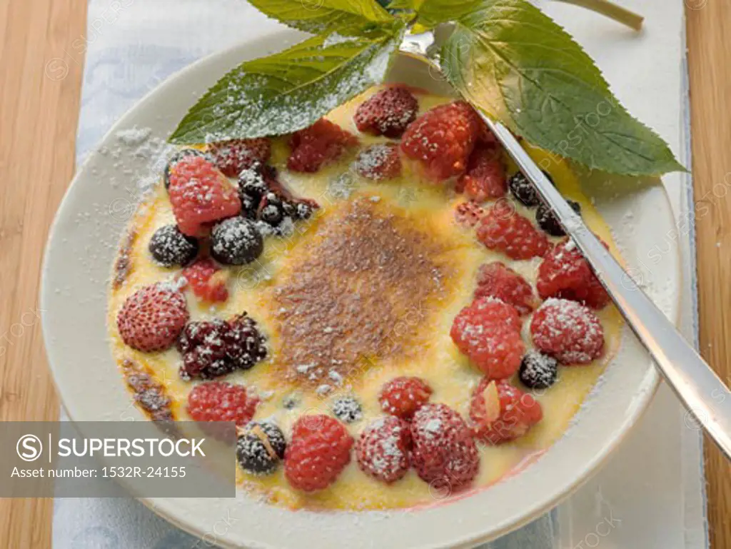 Crème brûlée with berries and icing sugar