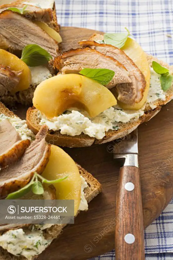 Open sandwiches of duck breast and apple on wooden board