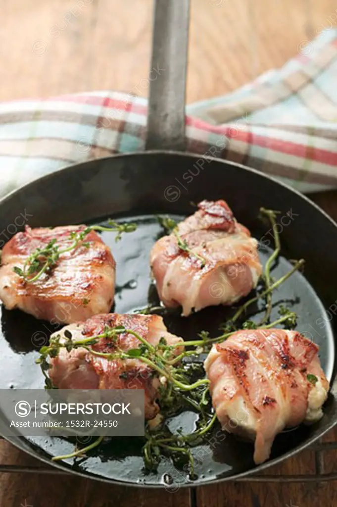 Goat's cheese wrapped in bacon in frying pan