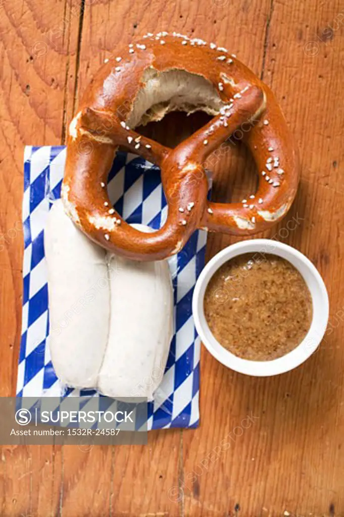 Two Weisswurst in packaging, pretzel & mustard