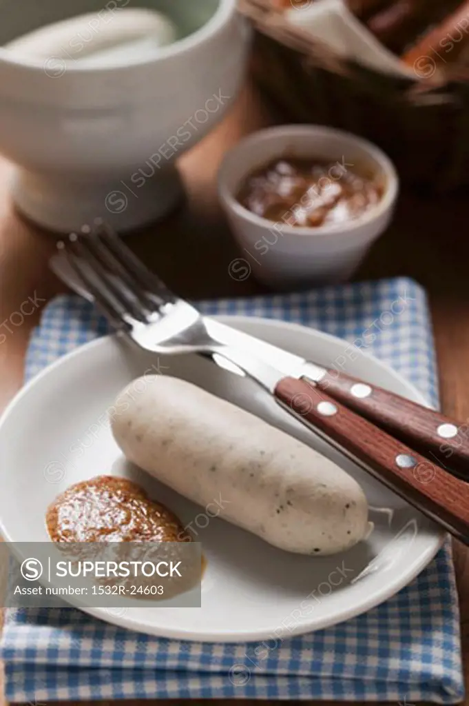 Cooked Weisswurst with mustard on plate