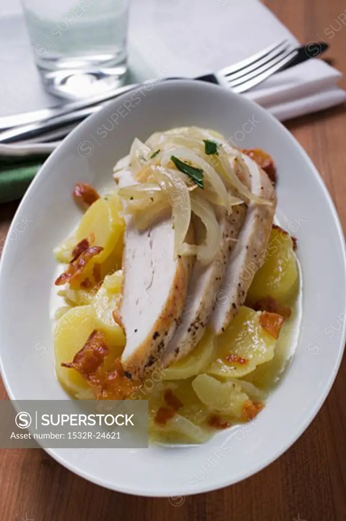 Potato salad with bacon, chicken breast and onions