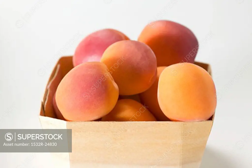 Several apricots in woodchip basket