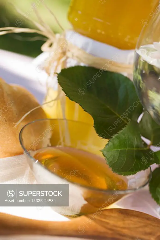 Honey in glass bowl in front of jars of honey