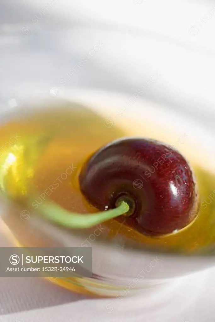 Honey with cherry in glass bowl