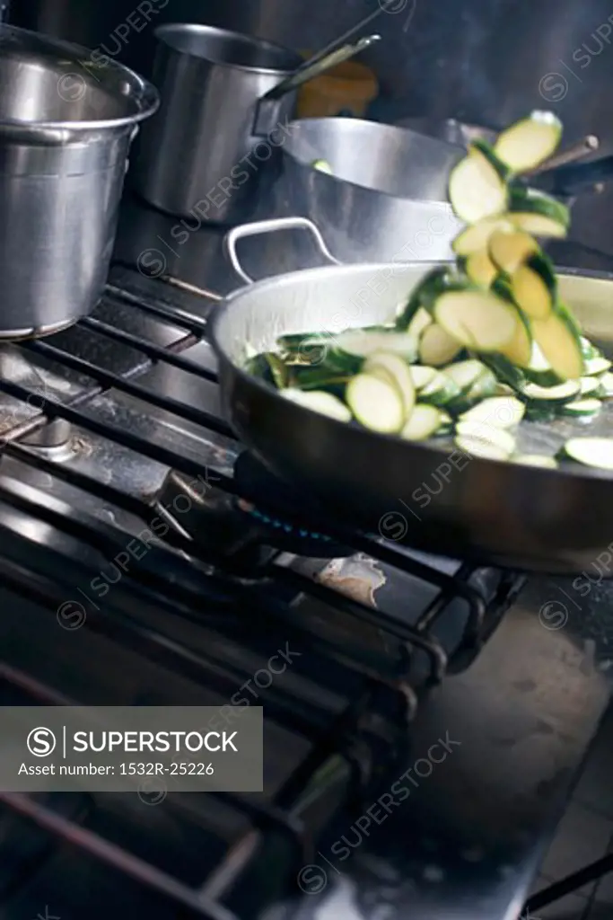 Tossing courgette slices in frying pan