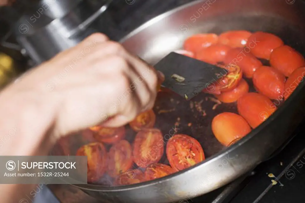 Turning tomatoes in frying pan
