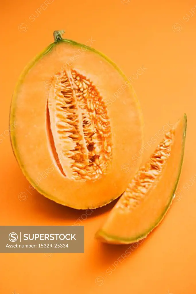 Half a cantaloupe melon with slice of melon