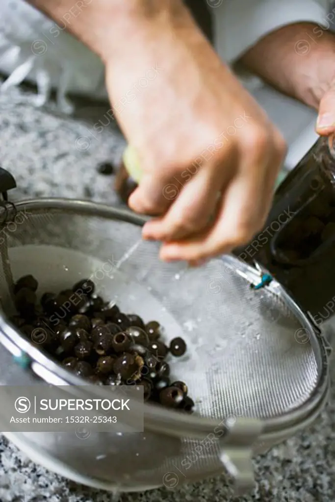 Draining black olives in a sieve