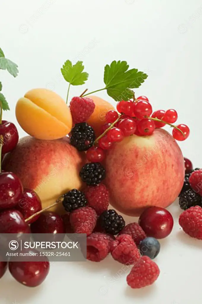Fruit still life with stone-fruit, berries and leaves