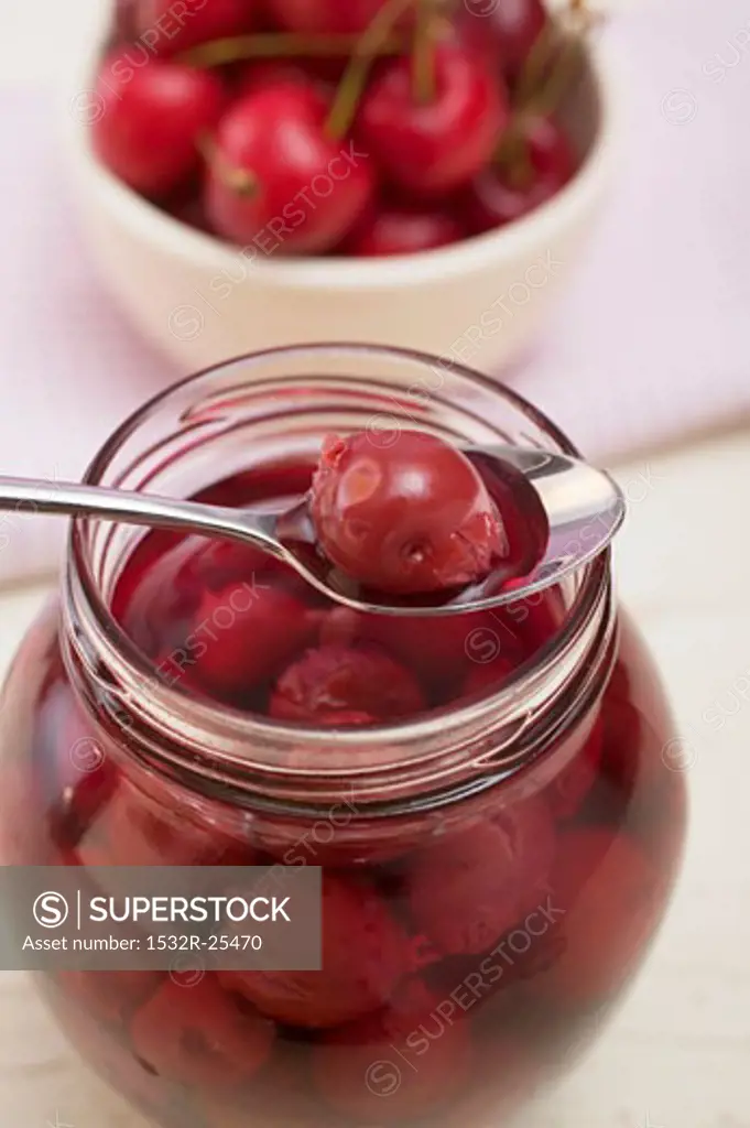 Cherry compote in jar and on spoon