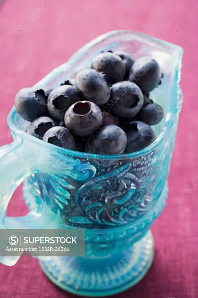 Fresh blueberries in light blue glass jug