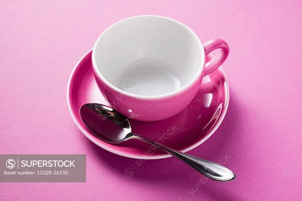 Pink coffee cup with spoon in saucer