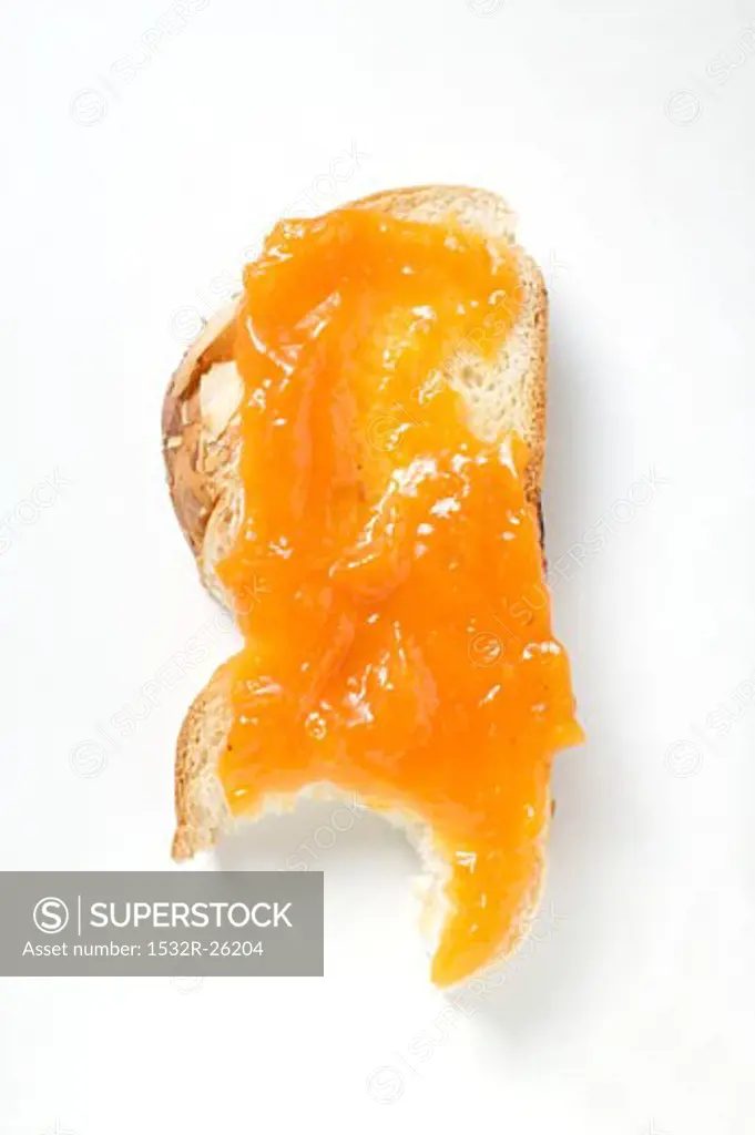 Slice of bread plait with apricot jam, a bite taken