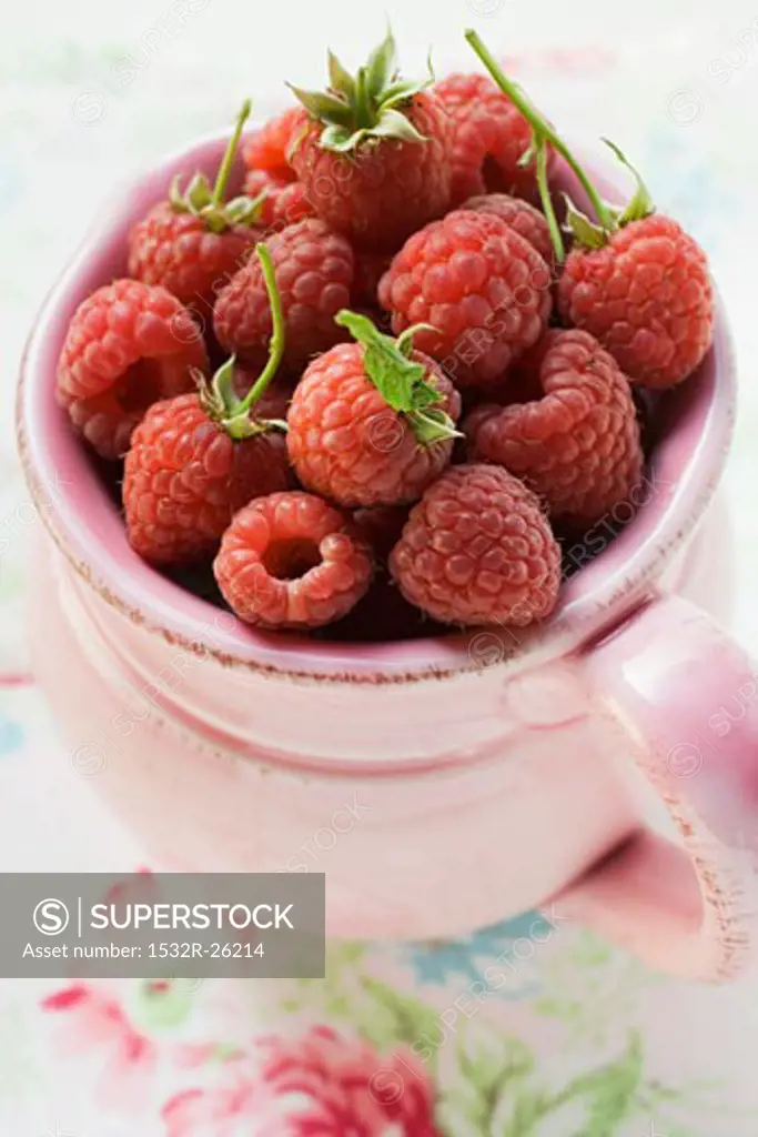 Fresh raspberries in a pink jug