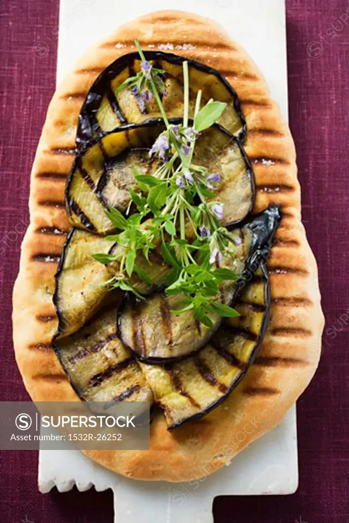 Grilled aubergine slices and herbs on pizza bread