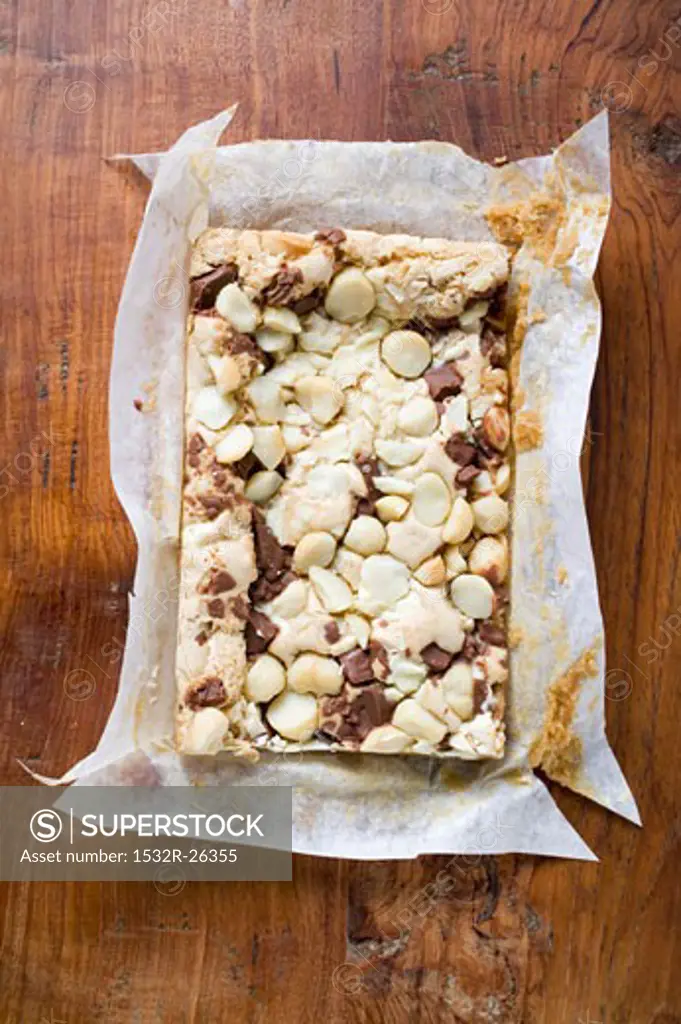 Chocolate slice with macadamia nuts in baking parchment
