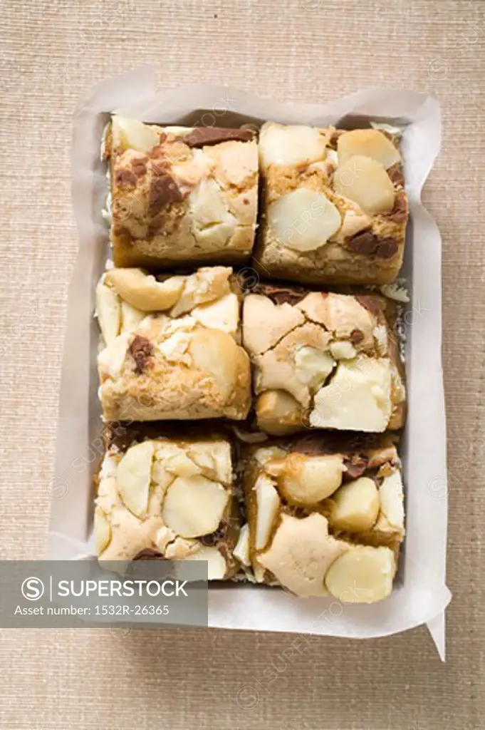 Small pieces of chocolate slice with macadamia nuts in box