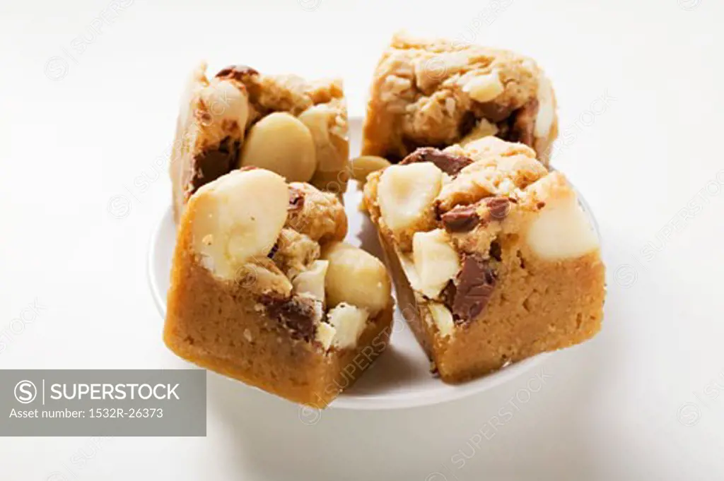 Small pieces of chocolate slice with macadamia nuts on plate