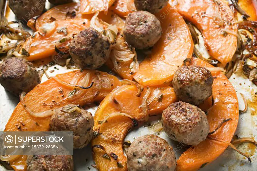 Meatballs with roasted pumpkin slices on baking tray
