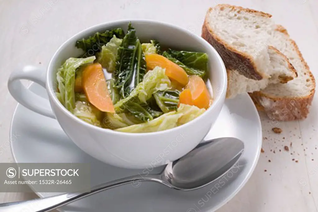 Savoy and carrot stew in soup cup, slices of bread